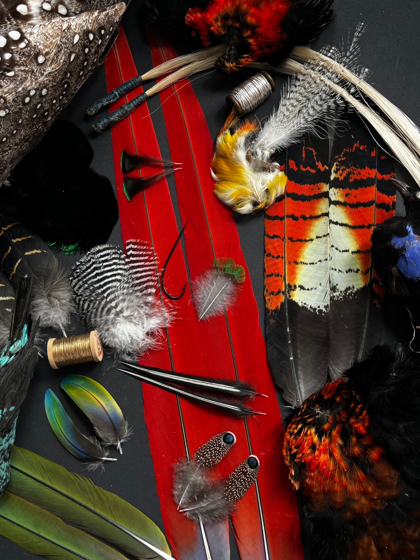 Feathers and fly-tying materials arranged on the workbench — exactly what you receive.
